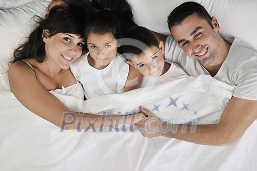 happy young Family in their bedroom have fun and play in bed happy young Family in their bedroom have fun and play in bed