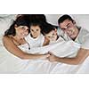 happy young Family in their bedroom have fun and play in bed