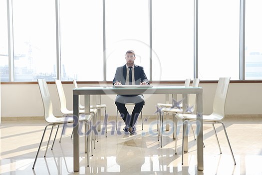 young business man lawyer with laptop alone in big bright conference room young business man lawyer with laptop alone in big bright conference room