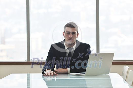 young business man lawyer with laptop alone in big bright   conference room