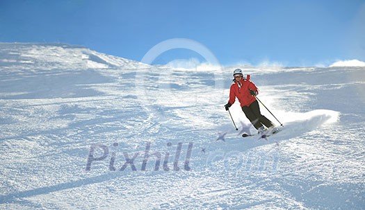 skier skiing downhill on fresh powder snow with sun and mountains in background skier skiing downhill on fresh powder snow with sun and mountains in background