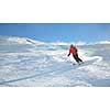 skier skiing downhill on fresh powder snow  with sun and mountains in background