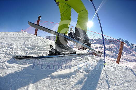 skier skiing downhill on fresh powder snow  with sun and mountains in background