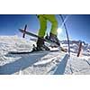 skier skiing downhill on fresh powder snow  with sun and mountains in background