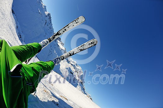 skier skiing downhill on fresh powder snow with sun and mountains in background skier skiing downhill on fresh powder snow with sun and mountains in background