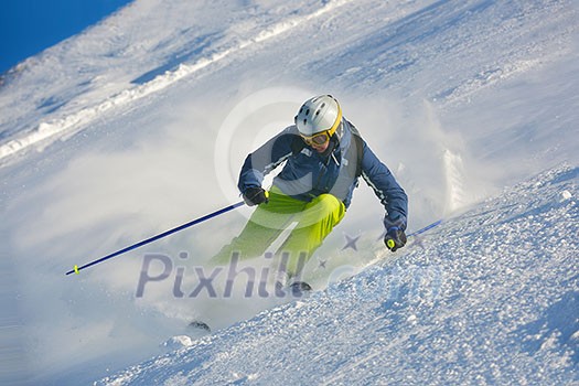 skier skiing downhill on fresh powder snow with sun and mountains in background skier skiing downhill on fresh powder snow with sun and mountains in background