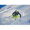 skier skiing downhill on fresh powder snow  with sun and mountains in background