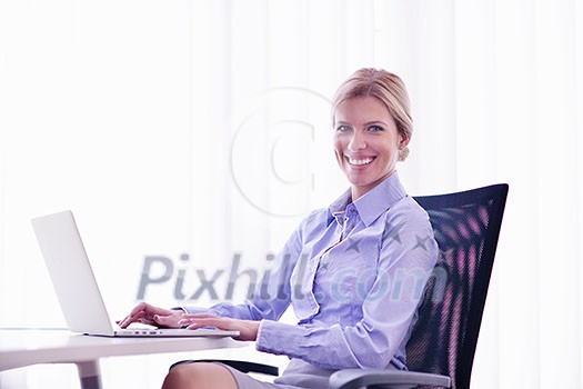 portrait of Young pretty business woman work on notebook computer in the bright modern office indoors portrait of Young pretty business woman work on notebook computer in the bright modern office indoors