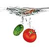 red tomato and green cucumber dropped into water isolated on white