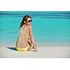 happy young pretty asian woman resting on sand at beach