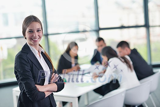 happy young business woman with her staff, people group in background at modern bright office indoors happy young business woman with her staff, people group in background at modern bright office indoors