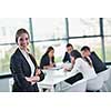 happy young business woman  with her staff,  people group in background at modern bright office indoors