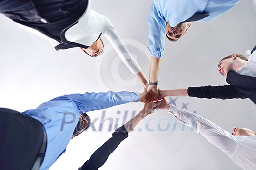 business people group joining hands and representing concept of friendship and teamwork, low angle view business people group joining hands and representing concept of friendship and teamwork, low angle view