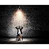 Image of young businesswoman sitting on chair under spot of light