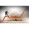 Image of businessman standing on graph and pulling it upwards