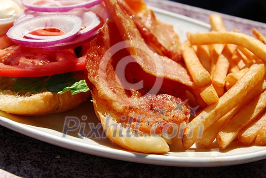 Canadian back bacon on a bun with fries dinner Canadian back bacon on a bun with fries dinner