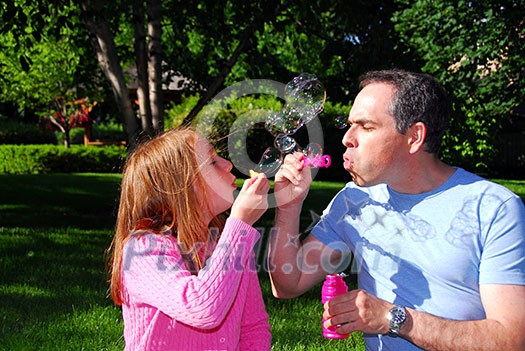 Happy family blowing soap bubbles, father and child Happy family blowing soap bubbles, father and child