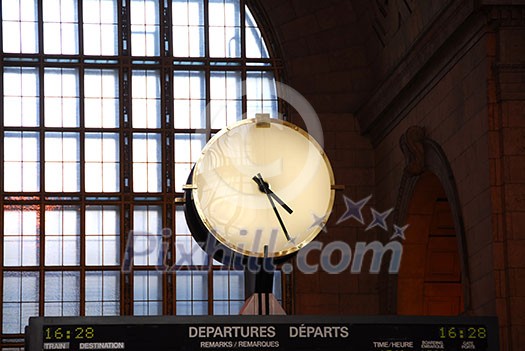 Big clock inside a train station on top of the time table Big clock inside a train station on top of the time table