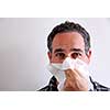 Man with a flu blowing his nose