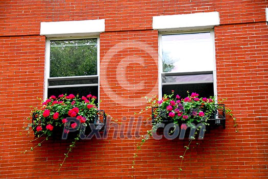 Fragment of a red brick house in Boston historical North End with wrought iron flower boxes Fragment of a red brick house in Boston historical North End with wrought iron flower boxes