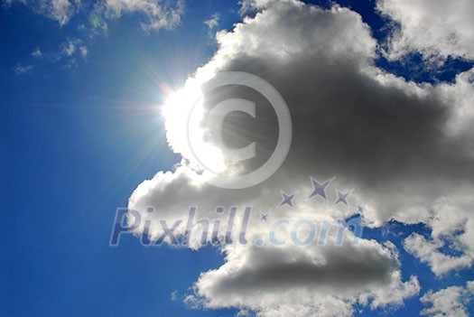 Sun coming out of the clouds in bright blue sky Sun coming out of the clouds in bright blue sky