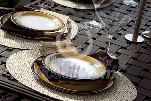 Table setting on a patio table with plates and martini glasses Table setting on a patio table with plates and martini glasses