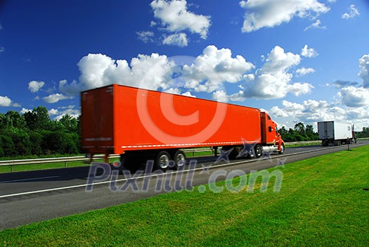 Bright red truck on road, blurred because of fast motion Bright red truck on road, blurred because of fast motion