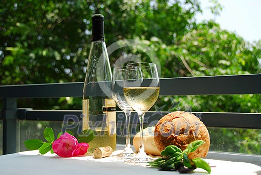 Table setting with chilled white wine and glasses alfresco Table setting with chilled white wine and glasses alfresco