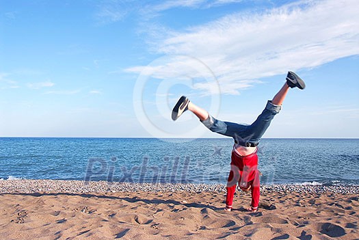 Young girl doing cartwheel on a beach Young girl doing cartwheel on a beach