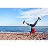 Young girl doing cartwheel on a beach