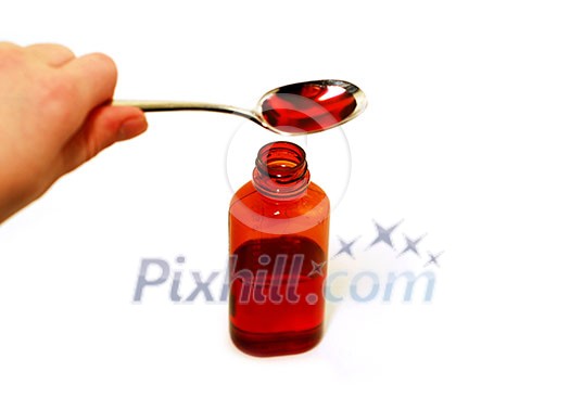 Cough syrup in a spoon and a bottle; shallow depth of field, focus is on top of the bottle Cough syrup in a spoon and a bottle; shallow depth of field, focus is on top of the bottle