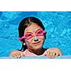 Portrait of a smiling girl in pink goggles in a swimming pool