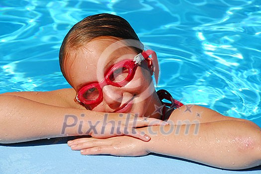 Portrait of a young girl in red goggles resting at the pool edge Portrait of a young girl in red goggles resting at the pool edge