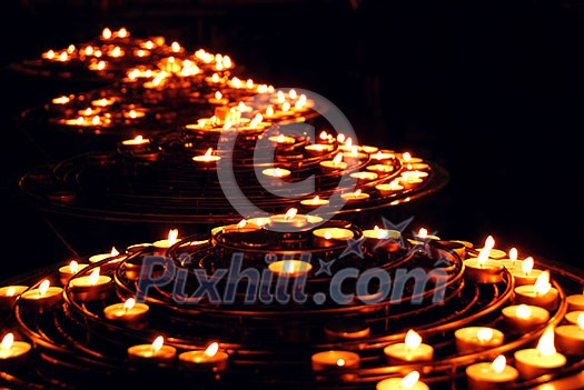 Rows of burning candles in a cathedral Rows of burning candles in a cathedral