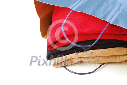 Folded sweaters in a paper shopping bag on white background Folded sweaters in a paper shopping bag on white background