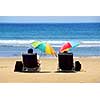 A couple relaxing on a beach under colorful umbrellas