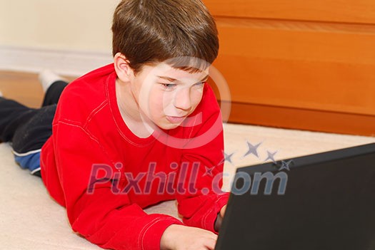 Little boy lying on the floor with portable computer Little boy lying on the floor with portable computer