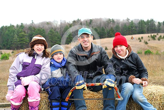 Family sitting on a vagon on Christmas tree farm Family sitting on a vagon on Christmas tree farm