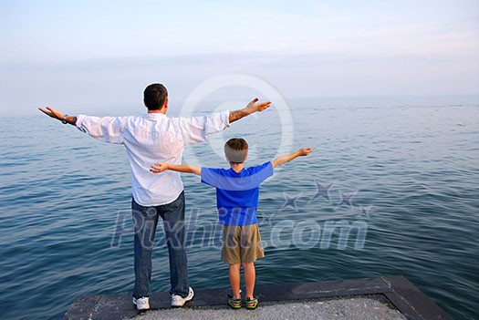 Father and son on a pier relaxing together Father and son on a pier relaxing together