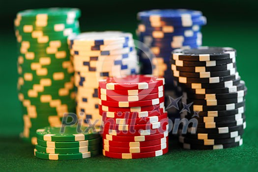 Stacks of gambling chips on green background Stacks of gambling chips on green background