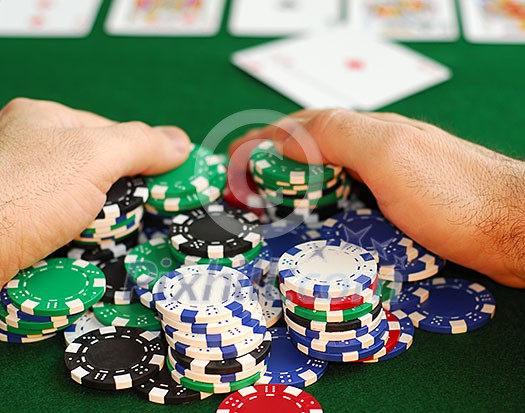Poker player raking a big pile of chips Poker player raking a big pile of chips