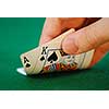 Man's hand lifting up playing cards at a poker table