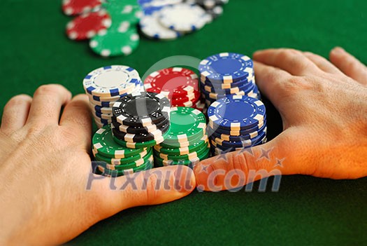Poker player going 'all in' pushing his chips forward Poker player going 'all in' pushing his chips forward