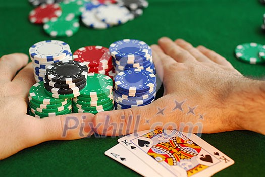 Poker player going 'all in' pushing his chips forward Poker player going 'all in' pushing his chips forward