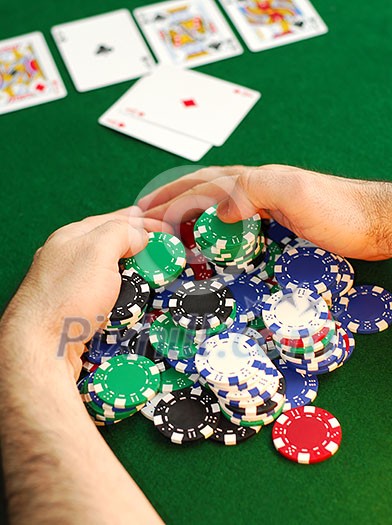 Poker player raking a big pile of chips Poker player raking a big pile of chips