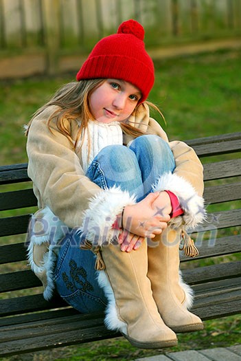 Portrait of a young girl sitting on a bench Portrait of a young girl sitting on a bench