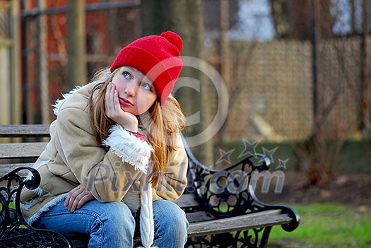 Portrait of a young girl sitting on a bench Portrait of a young girl sitting on a bench