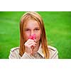Young girl holding a pink flower in her hand
