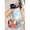 Man drilling a hole in a ceiling