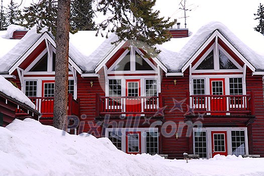 Log building of a mountain lodge in winter at ski resort Log building of a mountain lodge in winter at ski resort